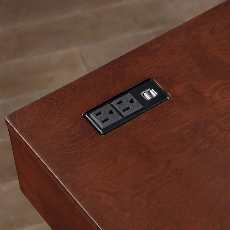 Un bureau en bois à deux tiroirs avec un port USB et une prise électrique.