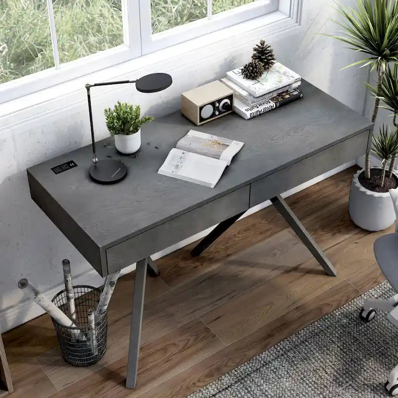 Un bureau en bois à deux tiroirs avec un port USB et une prise électrique.