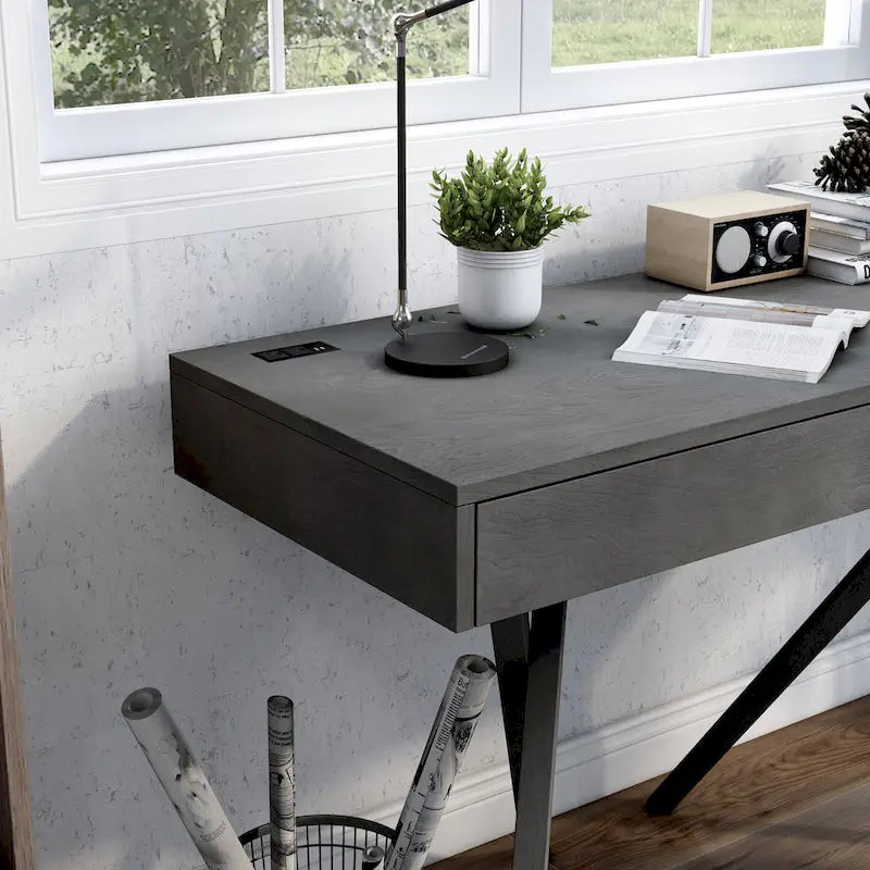 Un bureau en bois à deux tiroirs avec un port USB et une prise électrique.